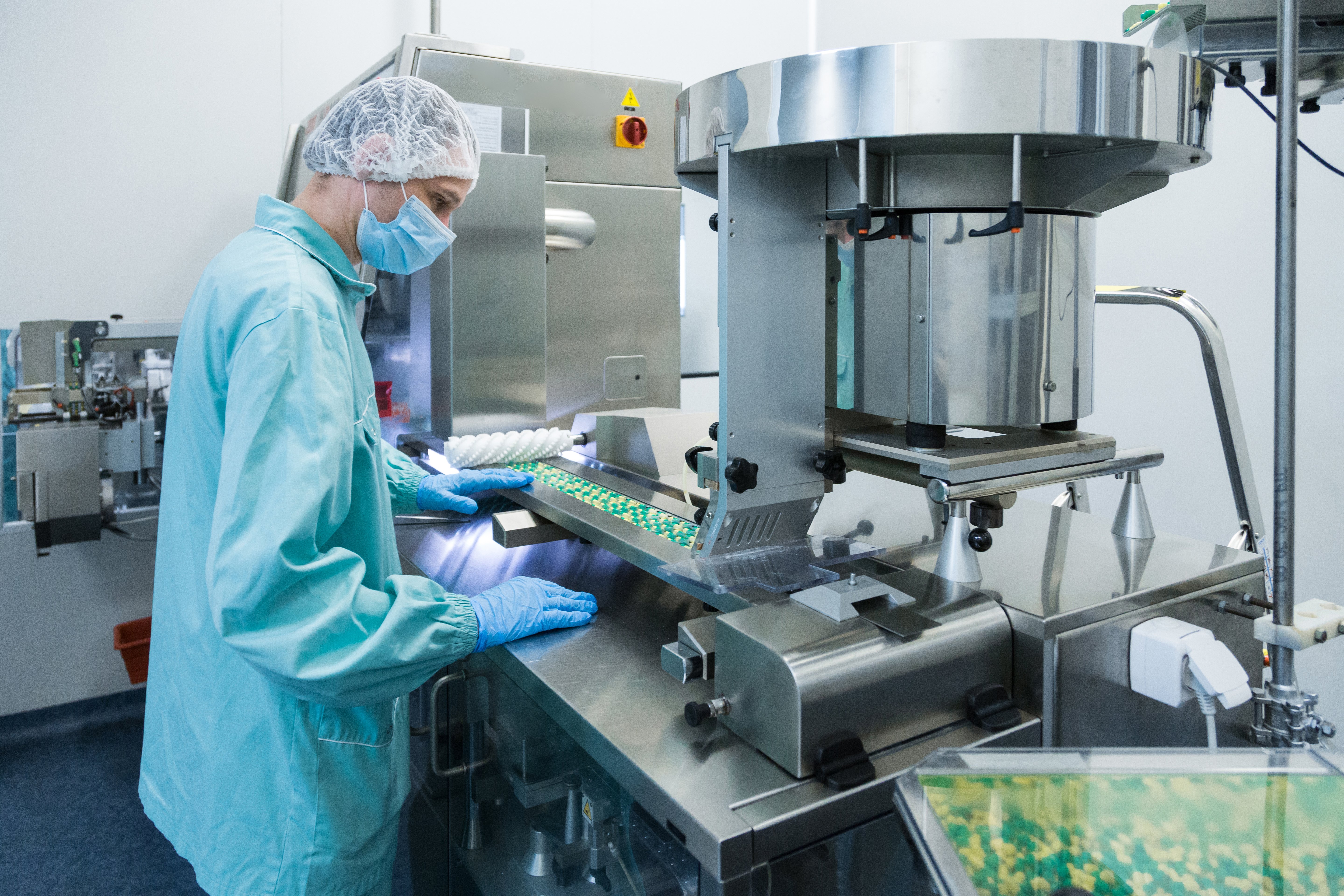 pharmaceutical-industry-man-worker-in-protective-clothing-operating-production-of-tablets-in-sterile-working-conditions